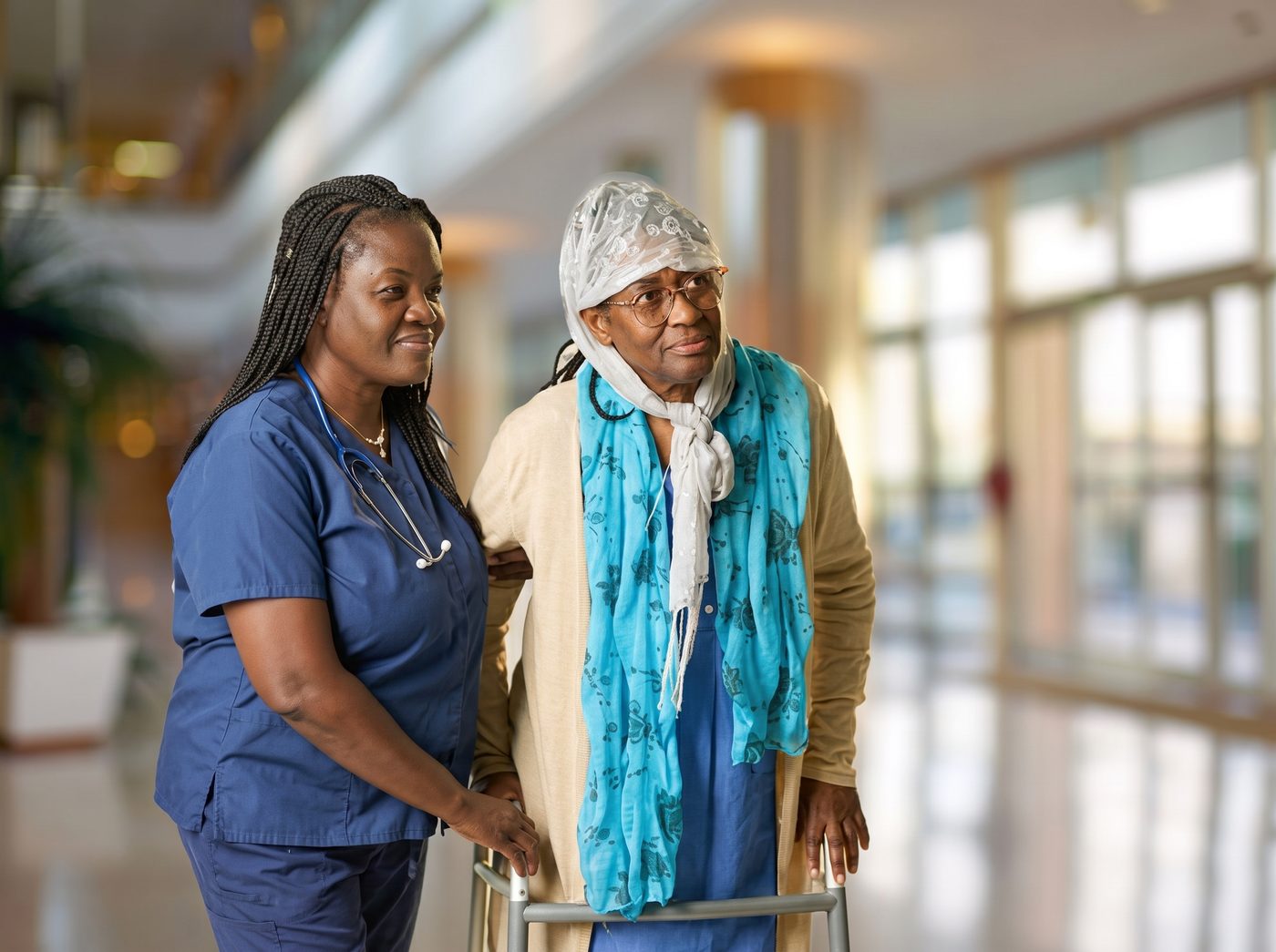 Nurse supporting a senior walking with a walker
